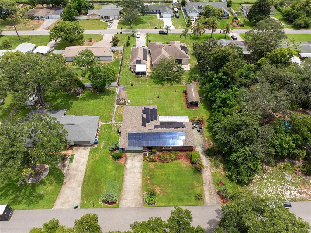 An aerial view shows a single-story house with solar panels on the roof and yard — 1435 PAULA DRIVE, APOPKA, FL