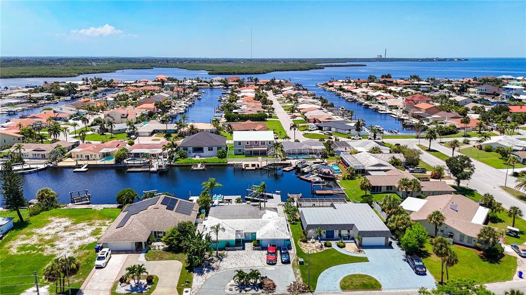 An aerial view shows waterfront houses with docks along a canal in a residential neighborhood — 3516 FLORAMAR TERRACE, NEW PORT RICHEY, FL