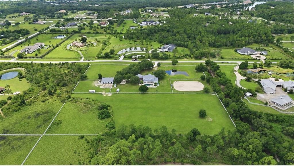 An aerial view shows a rural property with a house, outbuildings, pastures, and ponds — 20207 77TH AVENUE E, BRADENTON, FL