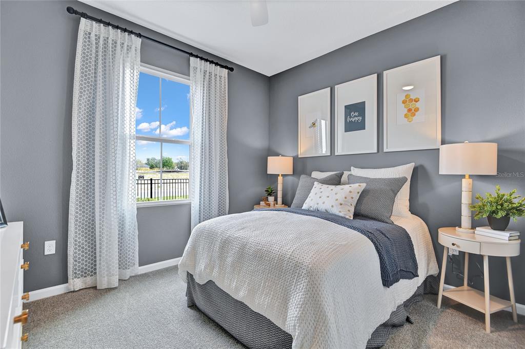 A bedroom features gray walls, a bed with white and blue bedding, and a window — 1249 DAISY HILL AVENUE, DUNDEE, FL