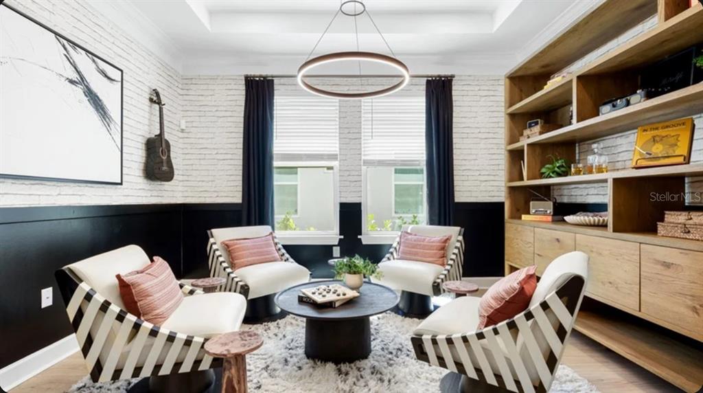 A dining room features a wooden table, cane-back chairs, a wine rack wall, and modern lighting — 7649 MOONBEAM AVENUE, SARASOTA, FL