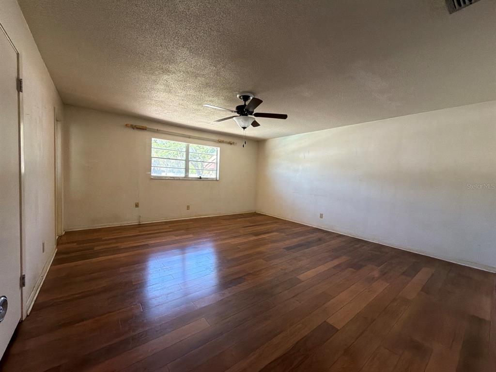 An empty room features wood-look flooring, a ceiling fan, and a single window — 3355 WILLIS ROAD, MULBERRY, FL