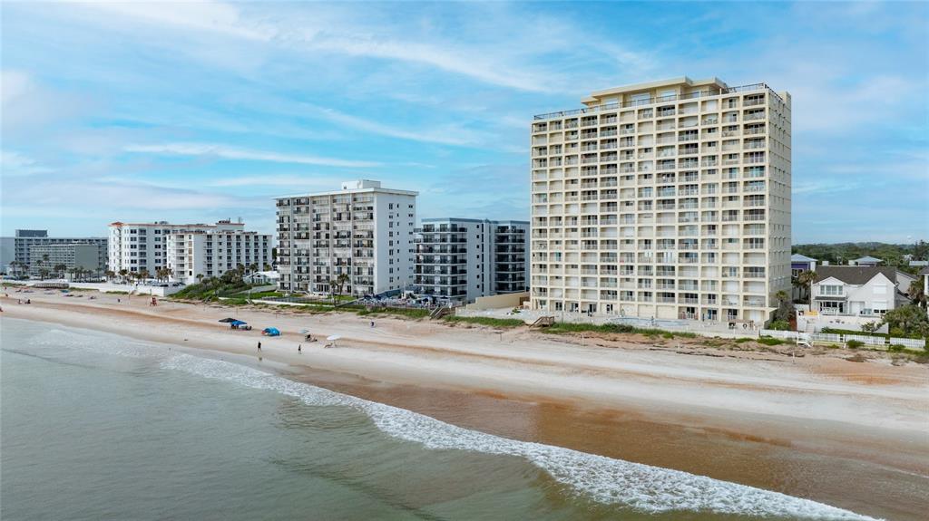 An aerial view of several beachfront high-rise apartment buildings along a sandy coastline — 89 S ATLANTIC AVENUE UNIT 1503, ORMOND BEACH, FL