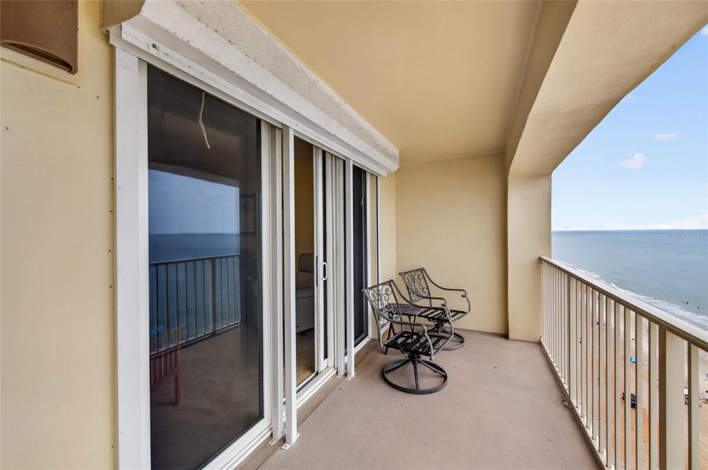 A balcony with metal chairs overlooks the ocean through a white railing — 89 S ATLANTIC AVENUE UNIT 1503, ORMOND BEACH, FL