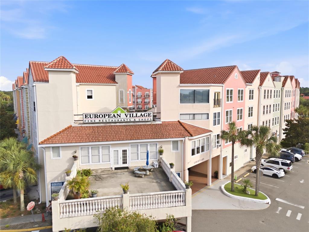 A living area with tile floors, a tray ceiling, a television, and two arched mirrors — 101 PALM HARBOR PKWY UNIT B418, PALM COAST, FL