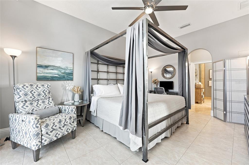 A living room with a sofa, armchair, and ottoman opens to a kitchen with wood cabinets — 101 PALM HARBOR PKWY UNIT B418, PALM COAST, FL