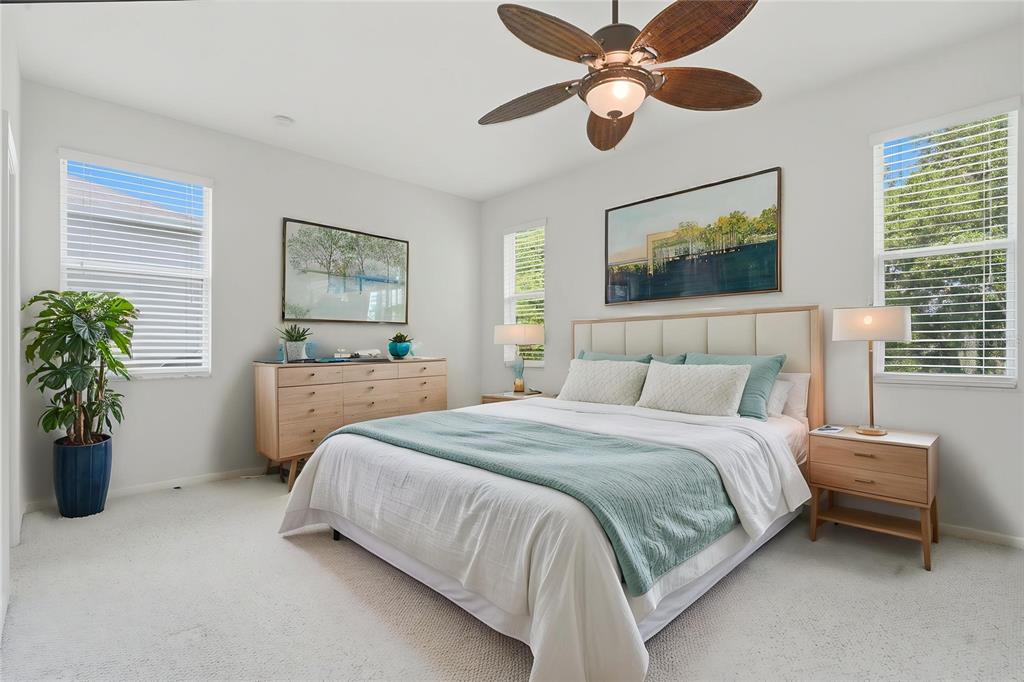 A bedroom features a bed with a light blue throw, wooden furniture, and a ceiling fan — 4203 ROCK HILL LOOP, APOPKA, FL