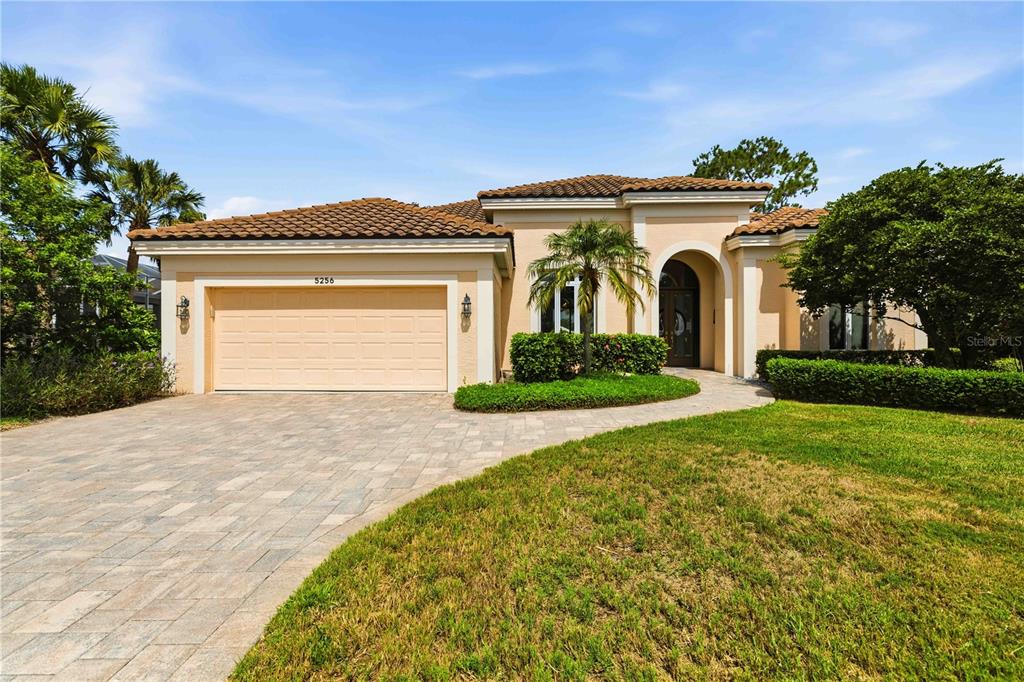 A screened-in patio features a built-in hot tub, stone pavers, and views of a pond — 5256 E 88TH STREET, BRADENTON, FL
