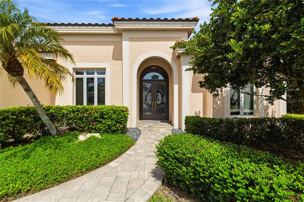 A screened-in patio features a circular spa, paver flooring, and outdoor seating — 5256 E 88TH STREET, BRADENTON, FL
