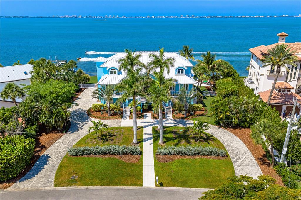 An aerial view of a blue waterfront house with a paved driveway and palm trees — 350 S SHORE DRIVE, SARASOTA, FL