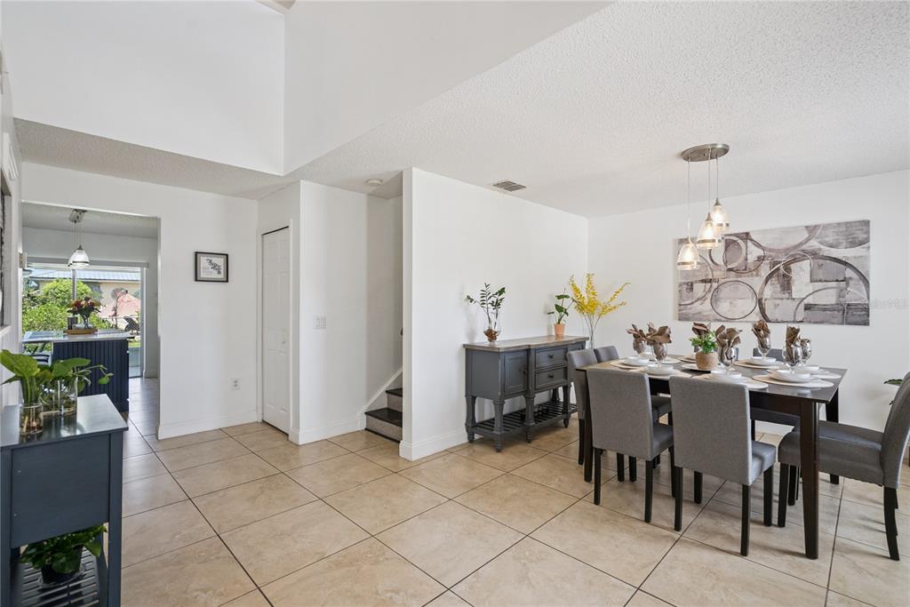 A dining room with tile floors, a dark wood table, and a gray sideboard — 2330 DOVER STREET, DELTONA, FL