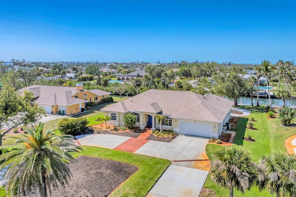 An aerial view of a suburban house with a tan exterior and a large driveway — 285 SPANIARDS ROAD, PLACIDA, FL