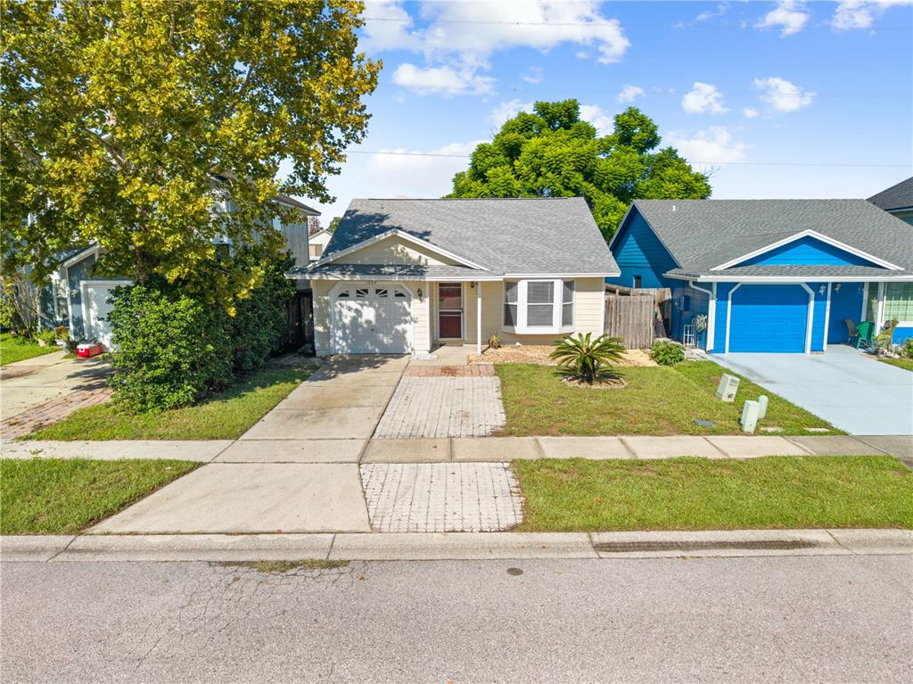A single-story house with a beige exterior, a gray roof, and a paved driveway — 1094 MARTIN BOULEVARD, ORLANDO, FL