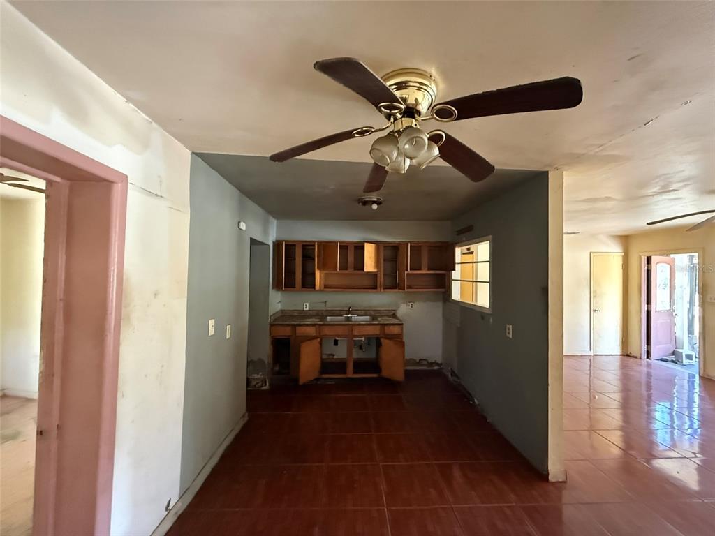 A kitchen with wooden cabinets and tile flooring sits under a ceiling fan — 816 17TH COURT E, BRADENTON, FL