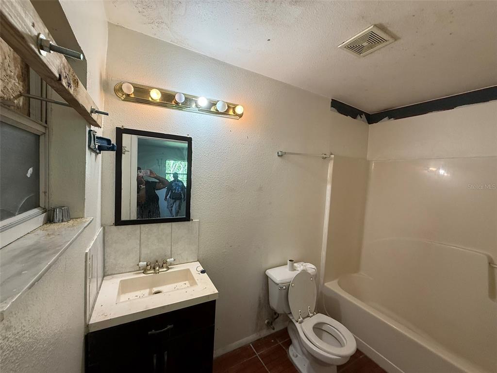 A bathroom features a vanity with a sink, a toilet, and a shower-tub combination — 816 17TH COURT E, BRADENTON, FL