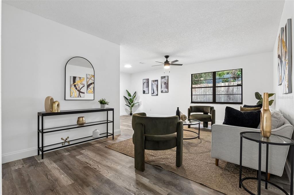 A living room with wood-look flooring, white walls, a ceiling fan, and modern furniture — 536 BISON CIRCLE, APOPKA, FL