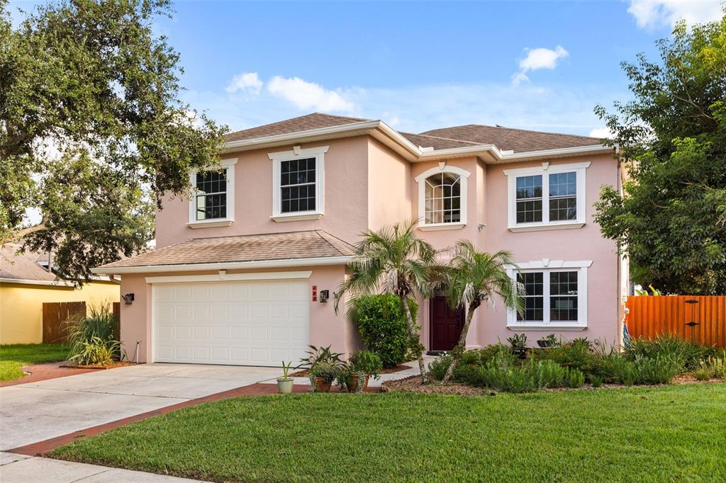 A two-story, pink stucco house with a two-car garage and a front lawn — 425 CARRIAGE WAY COURT, OVIEDO, FL