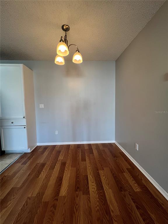 A living room with wood flooring, vaulted ceilings, a ceiling fan, and an open kitchen — 718 SUGAR BAY WAY UNIT 202, LAKE MARY, FL