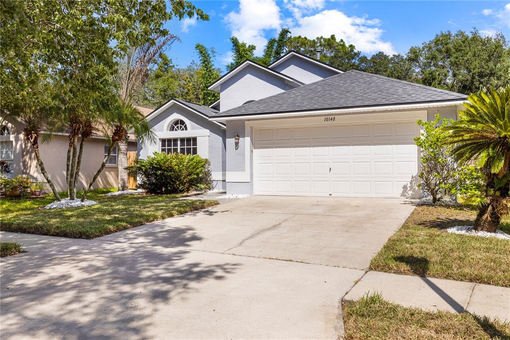 A single-story house with a white garage door, gray siding, and a concrete driveway — 10148 SOMERSBY DRIVE, RIVERVIEW, FL