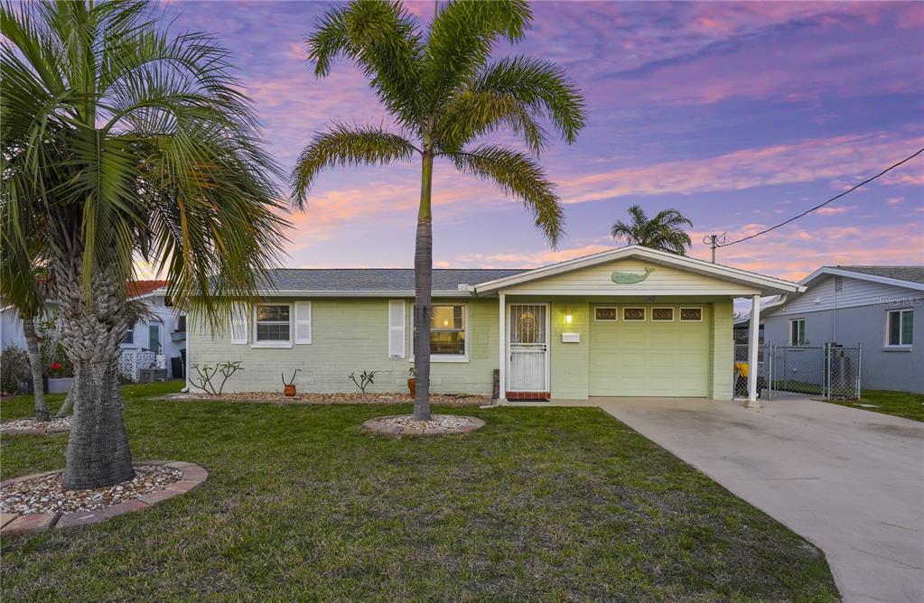 A screened-in swimming pool overlooks a canal at sunset — 12532 5TH ISLE, HUDSON, FL