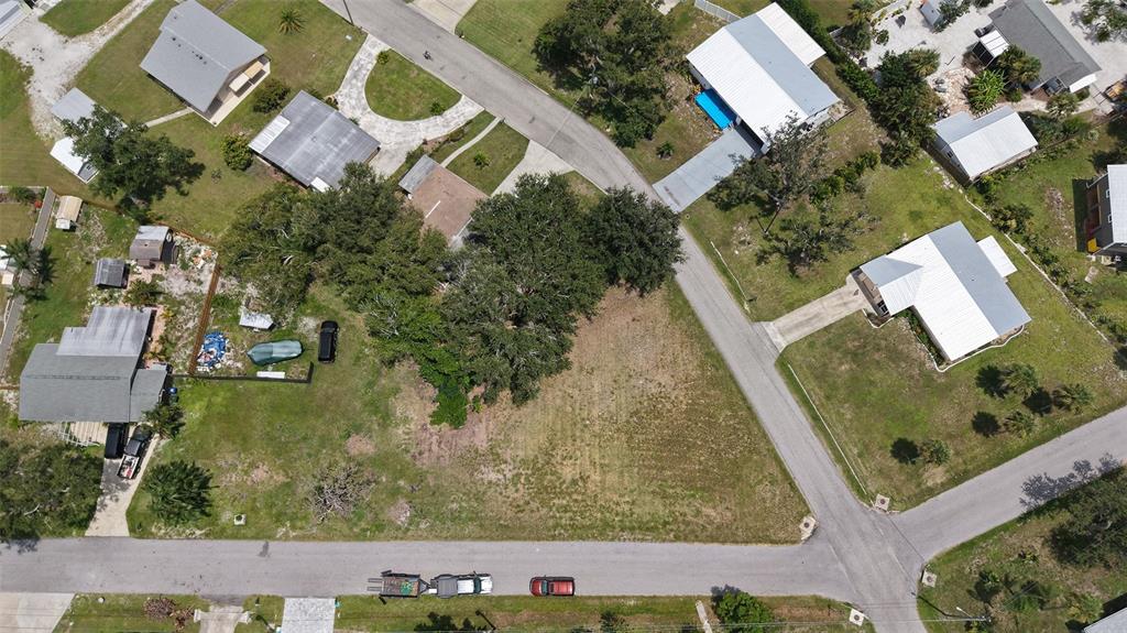 An aerial view shows a vacant residential lot surrounded by houses and paved streets — 513 PINE ROAD, NOKOMIS, FL