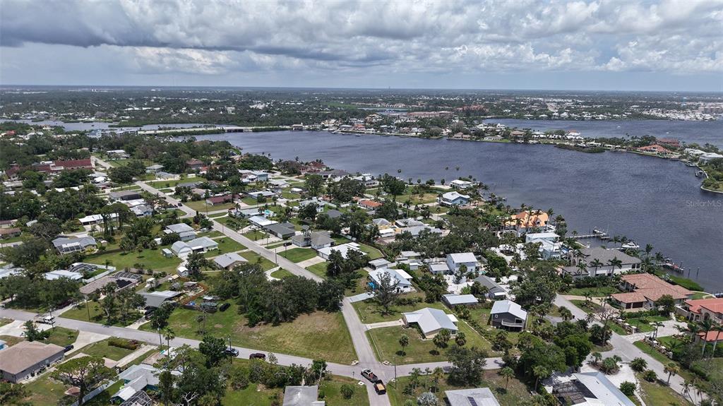 An aerial view shows a residential neighborhood situated along a large body of water — 513 PINE ROAD, NOKOMIS, FL