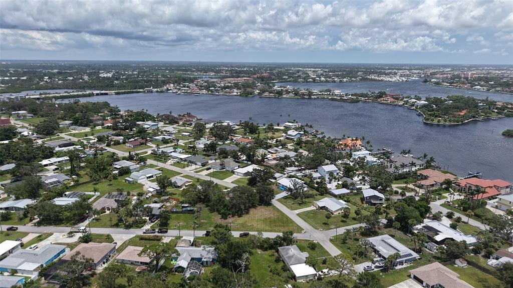 An aerial view shows a residential neighborhood situated along a large body of water — 513 PINE ROAD, NOKOMIS, FL