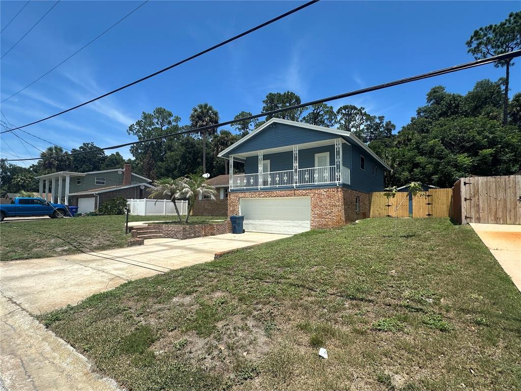 A blue two-story house with a brick lower level and an elevated front porch — 172 SEMINOLE DRIVE, ORMOND BEACH, FL