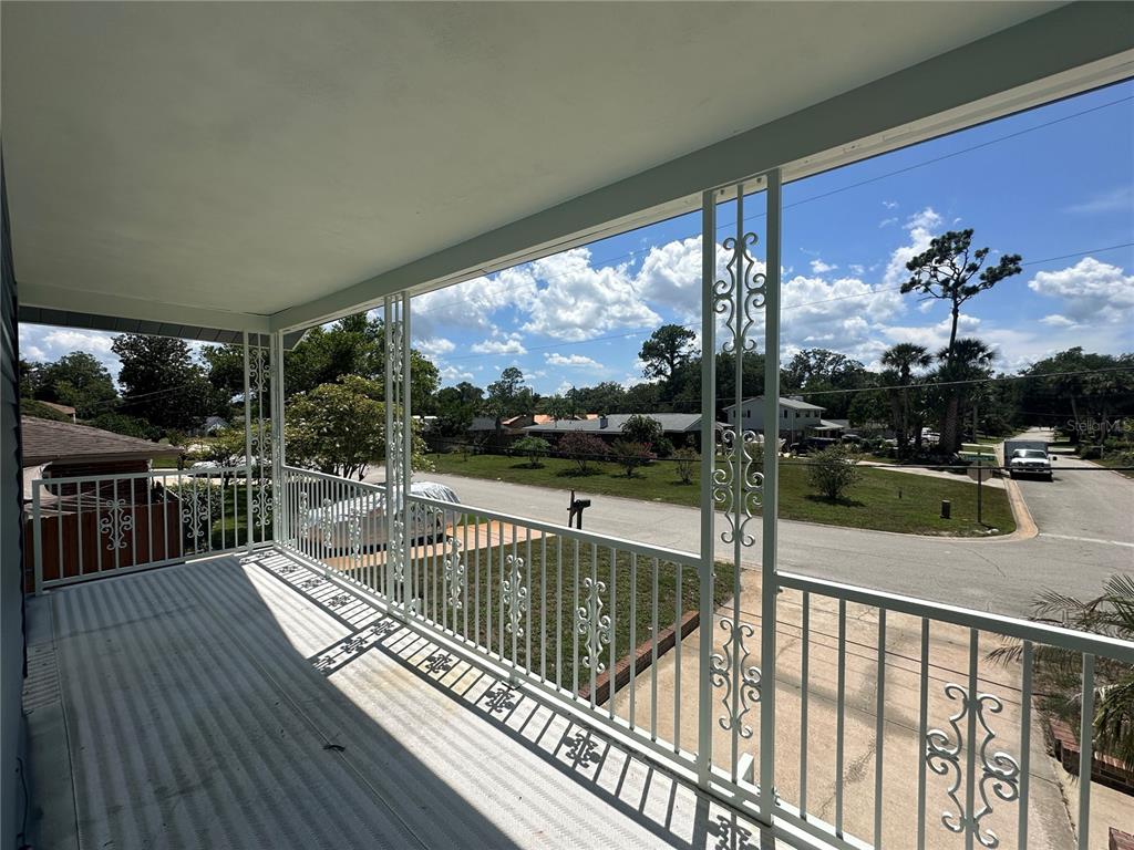 An elevated balcony features white metal railings with decorative scrollwork overlooking a suburban street — 172 SEMINOLE DRIVE, ORMOND BEACH, FL
