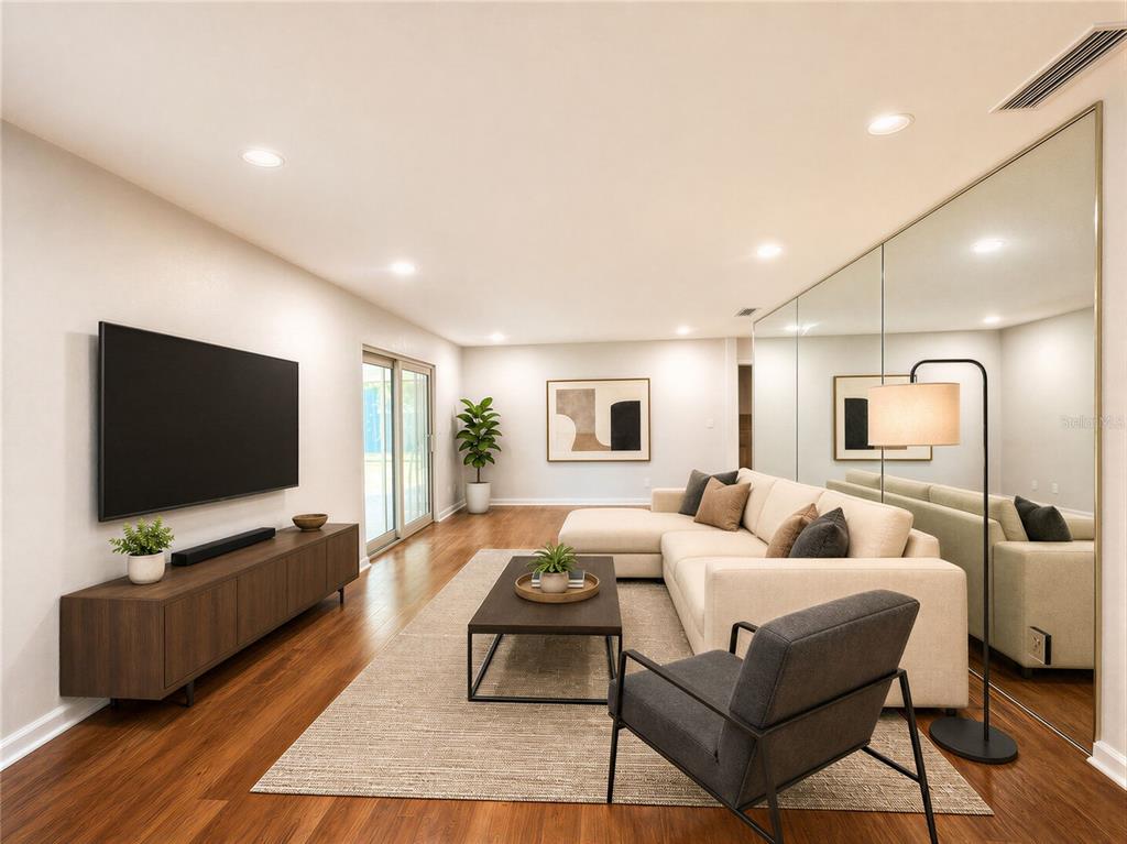 A living room features a sectional sofa, a television, a mirrored wall, and hardwood flooring — 172 SEMINOLE DRIVE, ORMOND BEACH, FL