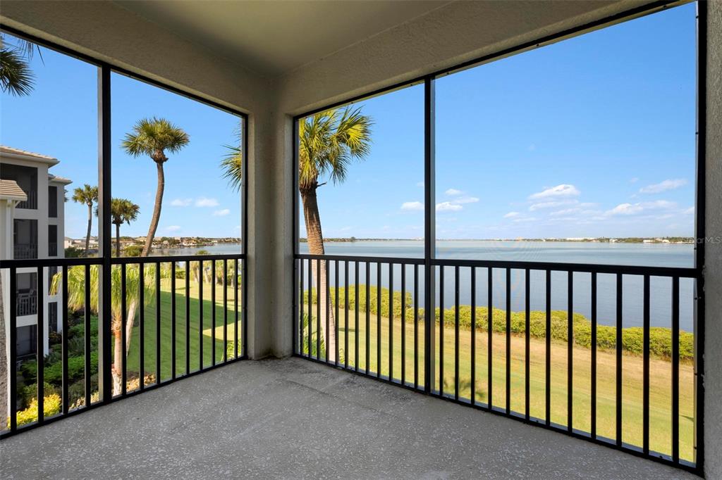 A multi-story apartment building exterior with palm trees and a central entrance labeled 820 — 920 TIDEWATER SHORES LOOP UNIT 301, BRADENTON, FL