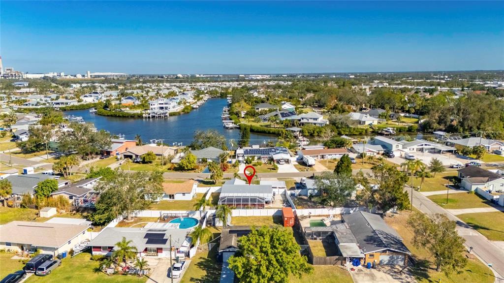 An aerial view shows a residential neighborhood with a canal and a marked house — 412 FLAMINGO DRIVE, APOLLO BEACH, FL