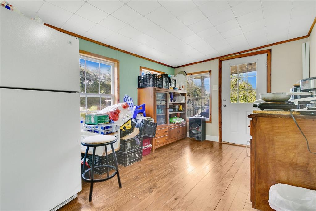 A kitchen with wood flooring, a white refrigerator, a wooden hutch, and a back door — 12531 NE 18TH STREET, WILLISTON, FL