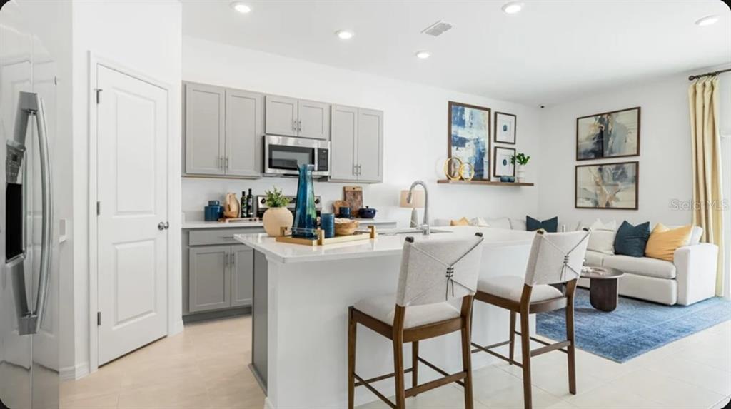 This floor plan shows the first level of a home with a garage, kitchen, and patio — 7195 GRAND FOREST WAY, NOKOMIS, FL