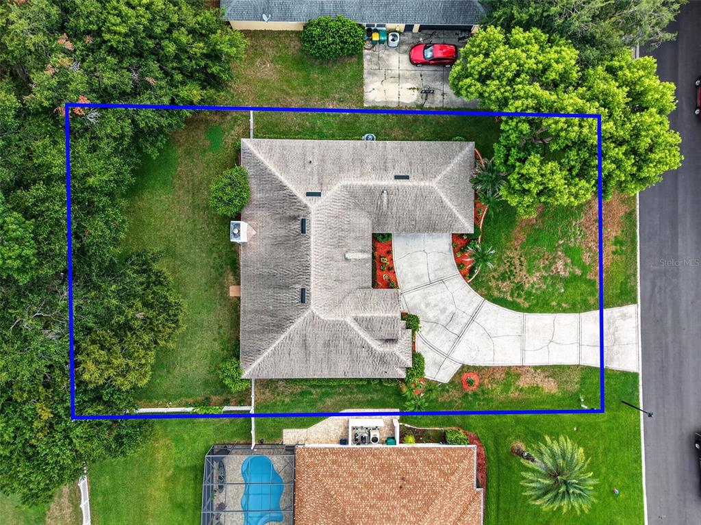 An aerial view shows a single-story house with a gray roof and a concrete driveway — 3237 INDIAN TRAIL, EUSTIS, FL