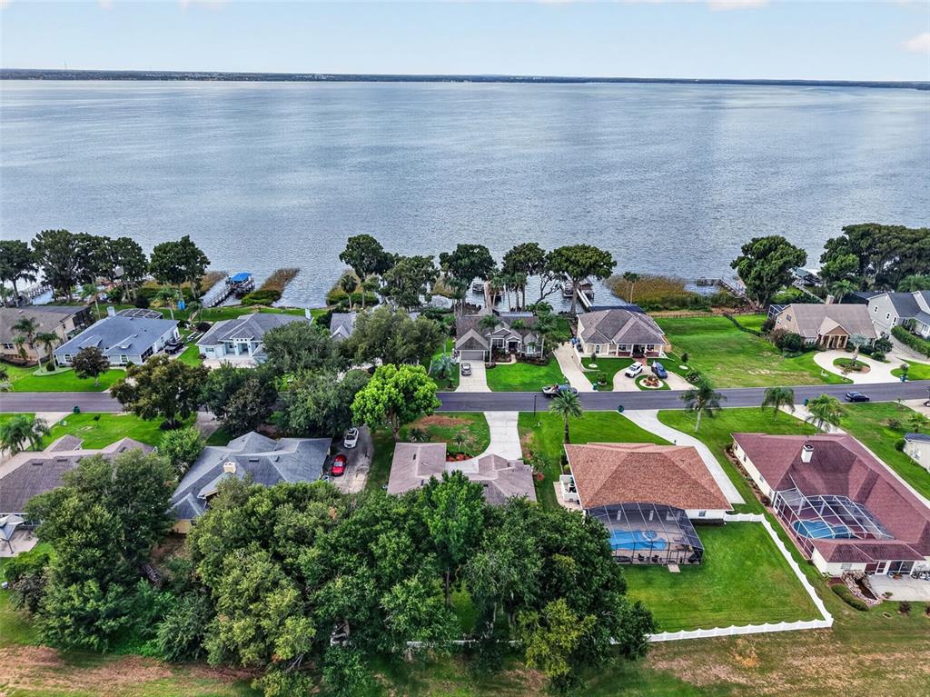 An aerial view shows several suburban houses situated along the shore of a large lake — 3237 INDIAN TRAIL, EUSTIS, FL