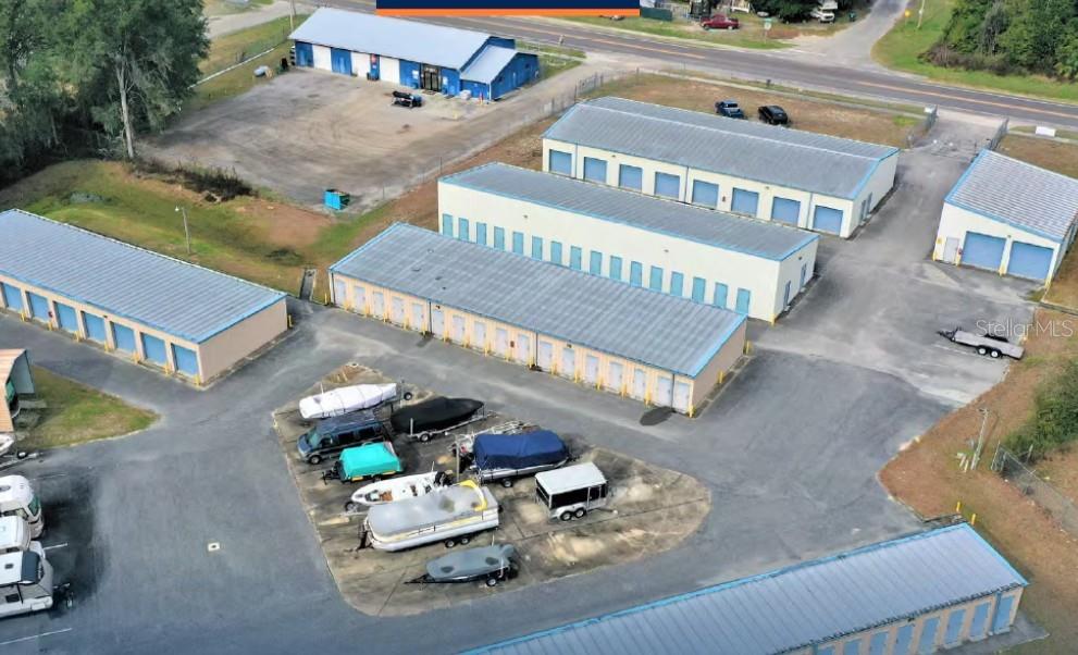 An aerial view shows a self-storage facility with multiple buildings and outdoor boat storage — 16881 SW ARCHER ROAD, ARCHER, FL