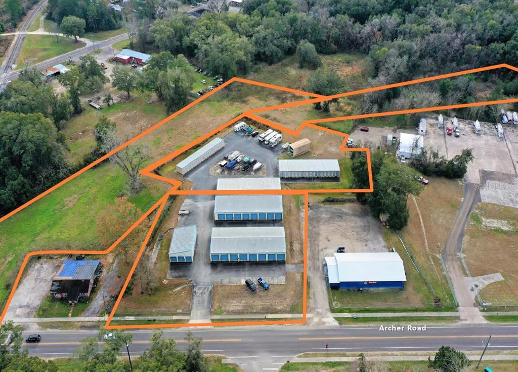An aerial view shows a commercial storage facility with multiple buildings and outdoor parking areas — 16881 SW ARCHER ROAD, ARCHER, FL