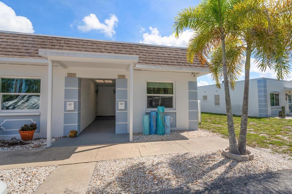 An aerial view shows a waterfront residential complex with private boat docks and green lawns — 599 WESTWINDS DRIVE UNIT 9, PALM HARBOR, FL
