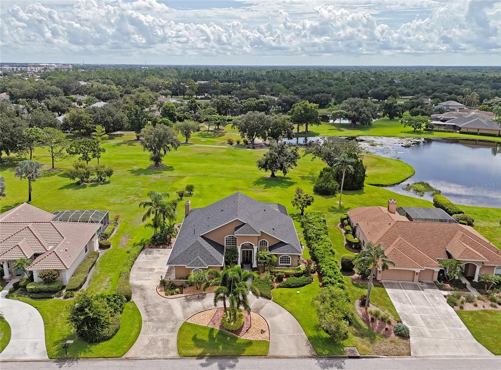 An aerial view shows a suburban house with a dark roof and a circular driveway — 6213 GLEN ABBEY LANE, BRADENTON, FL
