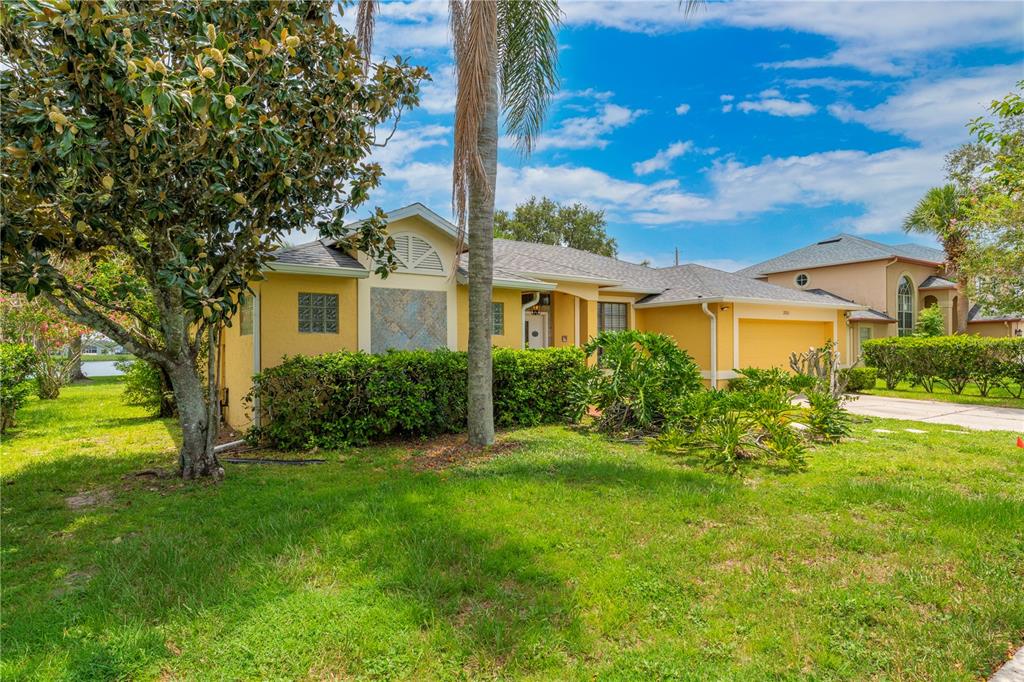 A single-story house with a yellow garage, a palm tree, and a concrete driveway — 2803 MIDDLETON CIRCLE, KISSIMMEE, FL