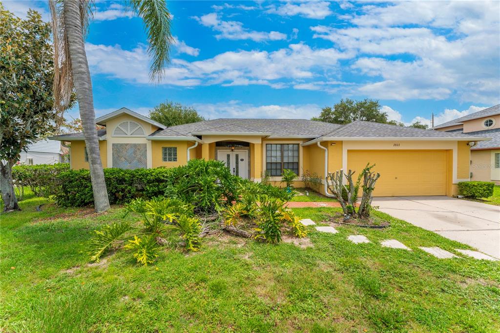 An aerial view of a single-story yellow house with a gray roof and a lake — 2803 MIDDLETON CIRCLE, KISSIMMEE, FL