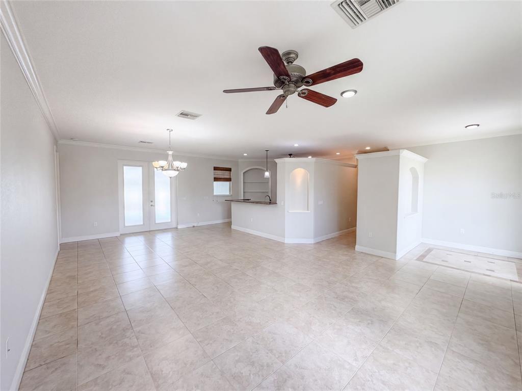 An open-concept living area features light tile flooring, a ceiling fan, and a kitchen island — 4625 GARDEN AVENUE, SEBRING, FL