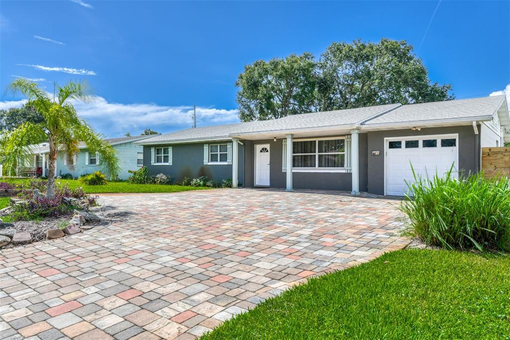 A single-story house with a gray exterior, white garage door, and a paved brick driveway — 15 SEA PARK DRIVE, ST AUGUSTINE, FL