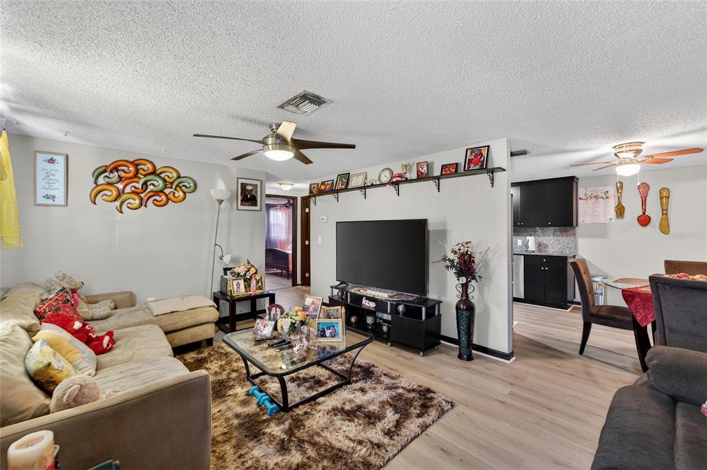 A living room with a television, a coffee table, and an adjacent dining area — 15821 ADOBE DRIVE, HUDSON, FL