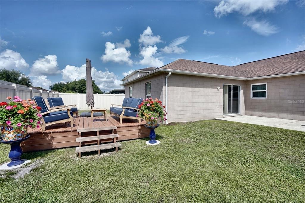 A single-story house with a tan stucco exterior, a two-car garage, and a front lawn — 712 BEAR WAY, POINCIANA, FL