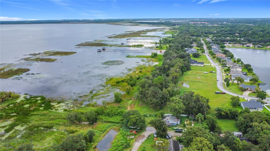 An aerial view shows a house situated on a large lot beside a lake — 4808 CALASANS AVENUE, ST CLOUD, FL