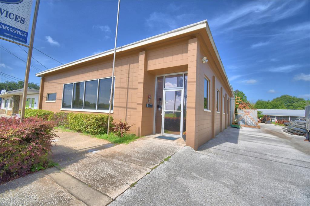 A tan, single-story commercial building with a glass front door and large windows — 221 N SCENIC HIGHWAY, FROSTPROOF, FL