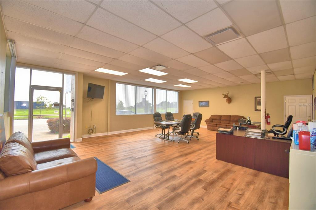 A commercial office space features wood-look flooring, a drop ceiling, and a leather sofa — 221 N SCENIC HIGHWAY, FROSTPROOF, FL