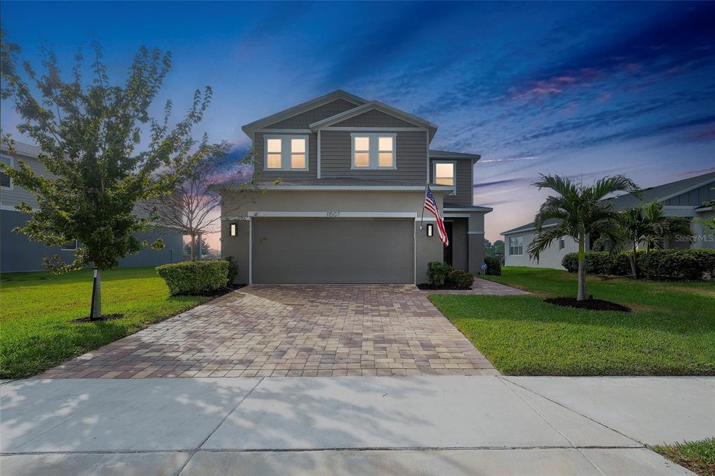 A two-story suburban house features a paved driveway, a two-car garage, and a front lawn — 11507 GALLATIN TRAIL, PARRISH, FL